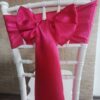 Fuchsiový satén (Fuchsia), šírka 15 cm, uviazaný do mašle na stoličke, pohľad zozadu