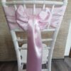 Pastelovo ružový satén (Baby Pink), šírka 15 cm, uviazaný do mašle na stoličke, pohľad zozadu